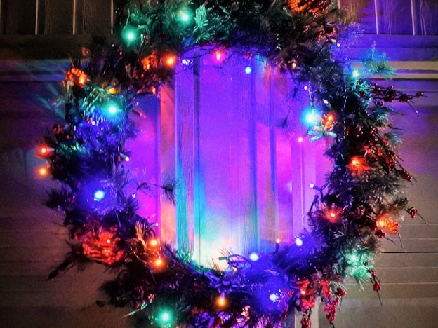 Christmas Wreath With Lights Hanging On A Garage Door
